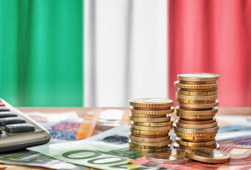 Euro banknotes and coins in front of the national flag of Italy